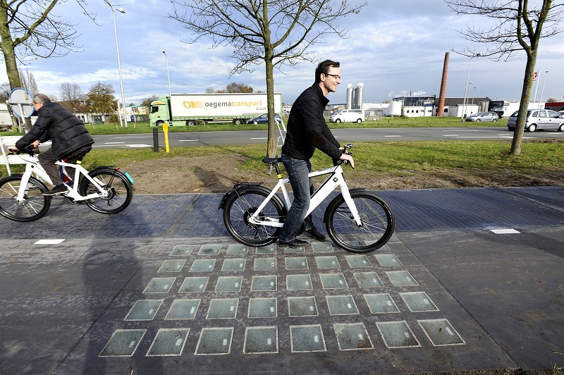 Cyclists use the SolaRoad, the first road in the world made of solar panels, during the official opening in Krommenie on November 12, 2014. The Netherlands unveiled the world's first solar bike path, a revolutionary project to harvest the sun's energy that could eventually also be used on roads. The so-called "SolaRoad" bike path is made of concrete modules each measuring 2.5 by 3.5 metres (eight by 11 feet), embedded with solar panels covered in tempered glass. AFP PHOTO/ANP/EVERT ELZINGA == NETHERLANDS OUT == (Photo credit should read EVERT ELZINGA/AFP/Getty Images)